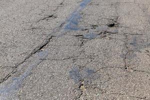 uma estrada de asfalto com muitos buracos e buracos foto
