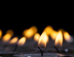 um grande número de pequenas velas queimando juntas foto