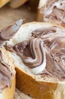 pão branco fatiado com cobertura de manteiga de chocolate doce foto