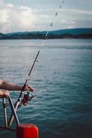 closeup de roda de vara de pescar, homem pescando do barco no mar