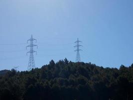 silhuetas de torres de metal de alta tensão nas montanhas foto