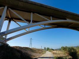 silhueta do arco de uma ponte moderna sobre uma estrada foto