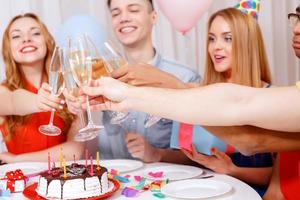 jovens comemorando um aniversário sentado à mesa
