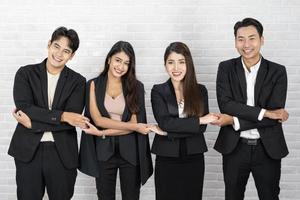 equipe de negócios segurando as mãos cruzadas um do outro. equipe criativa reunindo as mãos juntas na fila. jovens empresários estão de mãos dadas. conceito de unidade e trabalho em equipe. foto