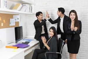 equipe de negócios feliz aplaudindo. pessoas de negócios trabalhando juntos no projeto e brainstorming no escritório. funcionários diversos amigáveis parabenizando a empresária com conquistas nos negócios. foto