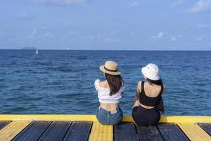 duas mulheres amigas ou casal relaxando e assistindo vistas juntos nas férias de verão de viagens de praia tropical. turistas do sexo feminino gostam de viajar para a natureza exótica em seu tempo de lazer. conceito de amizade foto