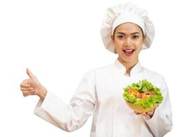 mulher asiática em uniforme de chef está cozinhando na cozinha foto