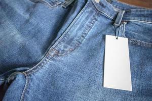 jeans azul com etiqueta de preço branco em branco foto