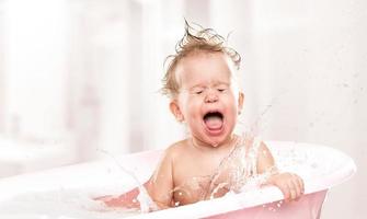 bebê engraçado feliz rindo e banhado no banho