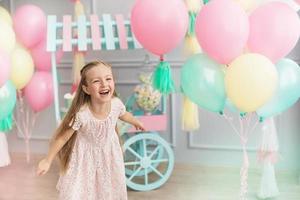 menina ri em um estúdio decorado muitos balões