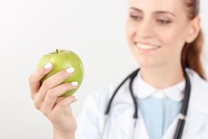 médico positivo, segurando a maçã verde