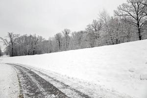 a estrada de inverno - a pequena estrada coberta de neve. Inverno foto