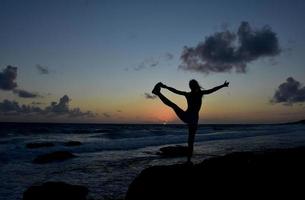 equilíbrio vincular pose ao nascer do sol em aruba foto