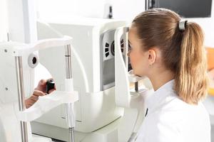 oftalmologista examina os olhos usando um dispositivo oftalmológico