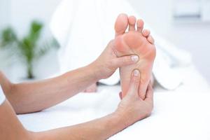fisioterapeuta fazendo massagem nos pés foto