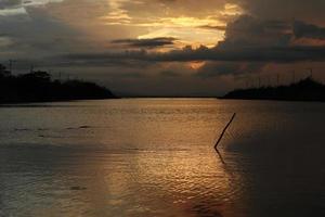 céu dramático colorido com nuvens ao pôr do sol. pôr do sol no lago foto