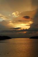 céu dramático colorido com nuvens ao pôr do sol. pôr do sol no lago foto