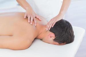 fisioterapeuta fazendo massagem no pescoço para seu paciente foto