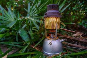 lâmpada de óleo antiga em um galho verde no forest.camping, foco ao ar livre concept.soft. foto