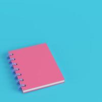 bloco de notas rosa sobre fundo azul brilhante em tons pastel foto