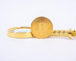 réplica de bitcoin dourado e lupa no conceito de background.business e finanças branco. foto