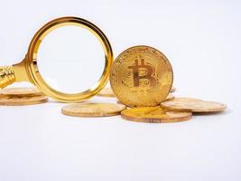 réplica de bitcoin dourado e lupa no conceito de background.business e finanças branco. foto