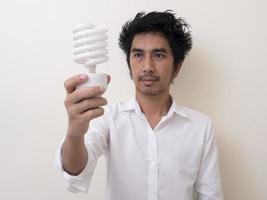 homem segurando lâmpada economizadora de energia para lâmpada foto
