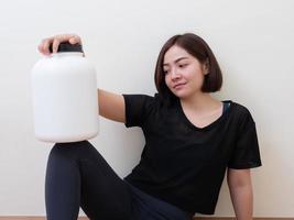 mulher esportiva com proteína de soro de leite foto