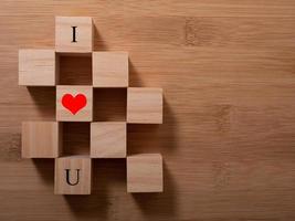 palavra amor em cubos de madeira com coração vermelho, close-up perto do conceito de fundo branco dos namorados foto