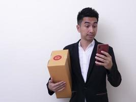 remetente jovem asiático segurando a caixa de papelão foto