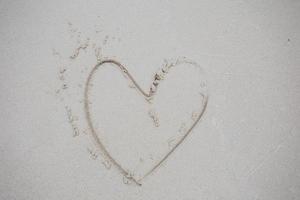 coração desenhado na areia foto