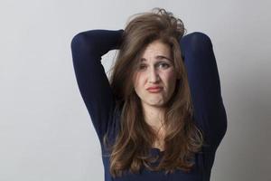 garota 20s irritada bagunçando o cabelo por frustração ou desacordo foto