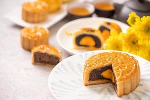 saboroso bolo de lua de pastel de gema de ovo cozido para o festival do meio do outono no fundo da mesa de madeira brilhante. conceito de comida festiva chinesa, close-up, copie o espaço. foto