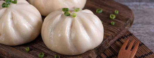 delicioso baozi, pão de carne no vapor chinês está pronto para comer no prato de servir e vaporizador, close-up, copie o conceito de design de produto do espaço. foto