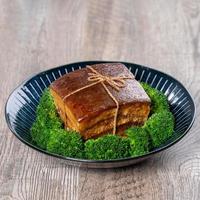 dong po rou dongpo carne de porco em uma bela placa azul com vegetais de brócolis verde, comida tradicional festiva para refeição de cozinha de ano novo chinês, close-up. foto