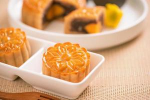 saboroso bolo de lua de pastel de gema de ovo cozido para o festival do meio do outono no fundo da mesa de madeira brilhante. conceito de comida festiva chinesa, close-up, copie o espaço. foto