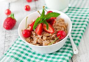 mingau de aveia com frutas em uma tigela branca foto