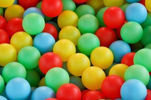 bolas de plástico coloridas em uma piscina infantil seca foto