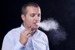 homens fumam um cigarro eletrônico foto