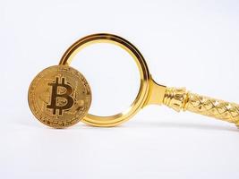 réplica de bitcoin dourado e lupa no conceito de background.business e finanças branco. foto