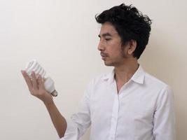 homem segurando lâmpada economizadora de energia para lâmpada foto