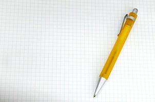 caneta amarela em papel milimétrico