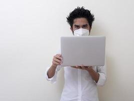 homem de negócios com máscara facial médica trabalha no laptop em casa