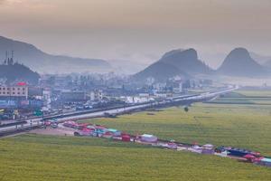 campo de flores de colza amarela com a névoa em luoping, china foto