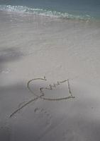 corações desenhados na areia de uma praia foto