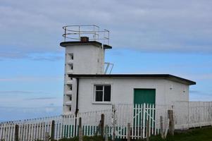 estação da guarda costeira caiada de branco localizada acima do mar da Irlanda foto