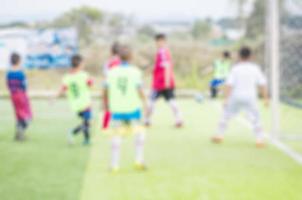 foto borrada de crianças estão praticando futebol no campo de futebol