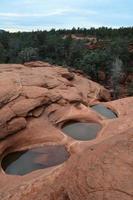 piscinas de água em camadas em rocha vermelha foto
