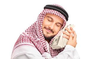 jovem árabe pessoa dormindo em dinheiro foto