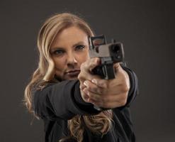 foco no atirador de mulher apontando a arma. foto